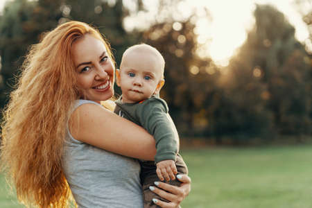 Portrait of a smiley mother posing with her baby. Copy space on left.の写真素材