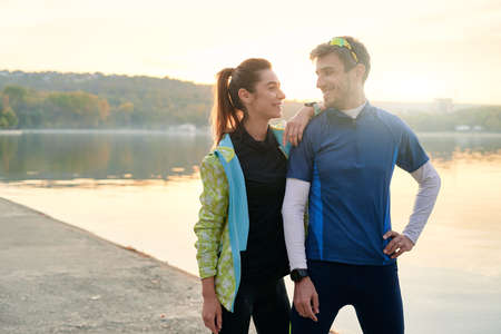 Sport motivation and healthy fitness lifestyle. Young couple of runners resting during outdoor morning workout.の写真素材