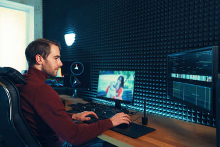 Confident Man Video Editor Works with Footage in Creative Office Studio.の写真素材