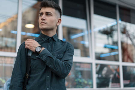 Portrait young man thinking of future on blurred city backgroundの写真素材