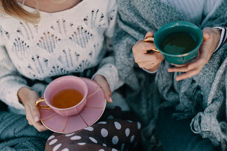 Two attractive girls enjoy a tea party. Drinking healthy buckwheat tea. Healthcare or herbal...
