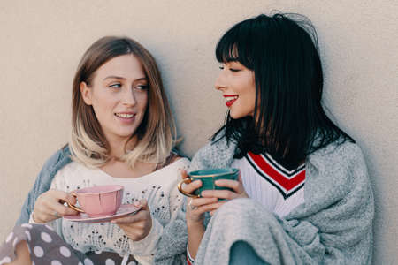 Two attractive girls enjoy a tea party. Drinking healthy buckwheat tea. Healthcare or herbal...