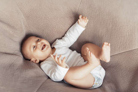 The kid is lying and having fun on a huge pillowの写真素材