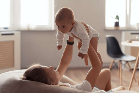 Young mother have fun with her baby at homeの写真素材