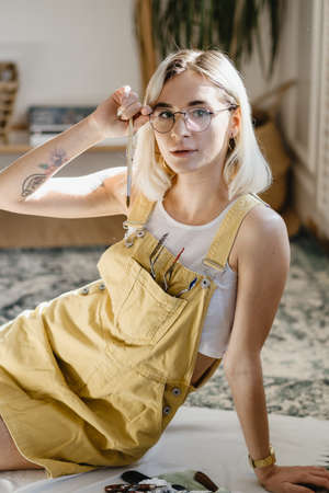 Beautiful young blonde woman portrait wearing glasses while posing indoor.の写真素材