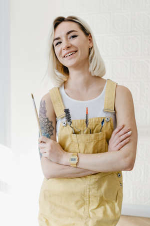 Portrait authentic blonde young woman posing with painting tools. Inspiring beauty concept. Art therapy.の写真素材