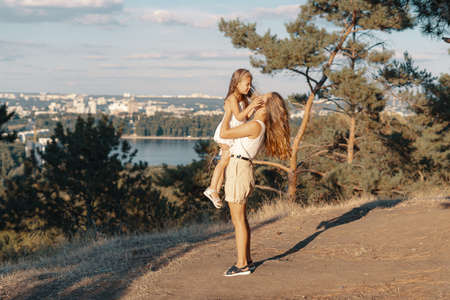 Joyfull young mother spend wonderful holiday time in the forest with her kid. Two blondies, mother and daughterの写真素材