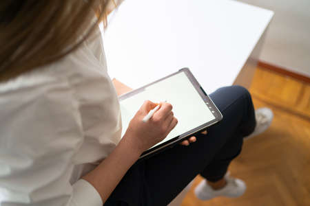 Business woman hands close up working with tablet in modern office wearing white shirt black pants
