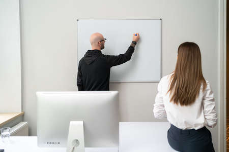 Business people discussing business ideas on white board. Young executive giving a presentation on...