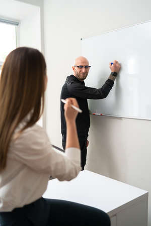 Business people discussing business ideas on white board. Young executive giving a presentation on white board to coworkers.の写真素材