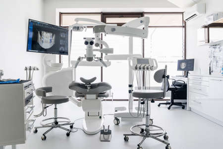 Interior of dental practice room with chair, lamp, display and stomatological toolsの写真素材