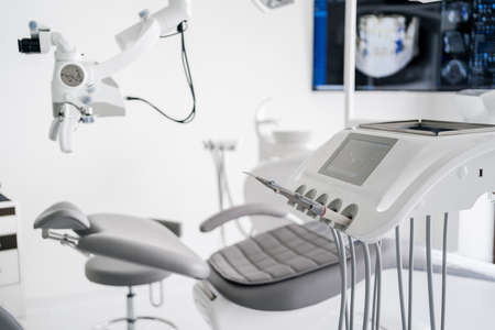 Interior of dental practice room with chair, lamp, display and stomatological toolsの写真素材