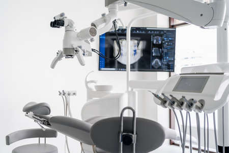 Interior of dental practice room with chair, lamp, dental scan on the display and stomatological toolsの写真素材