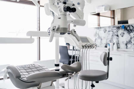 Interior of dental practice room with chair, lamp, display and stomatological toolsの写真素材