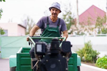 Satisfied farmer portrait sitting behind the wheel of a two-wheeled tractor.の写真素材