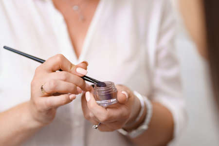 Close up working beautician hands. Professional makeup artist working with client in dressing roomの写真素材
