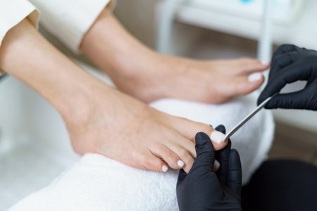 Specialist in beauty salon making french pedicure for female client. Relaxing at beauty salon, caring about nails.の写真素材