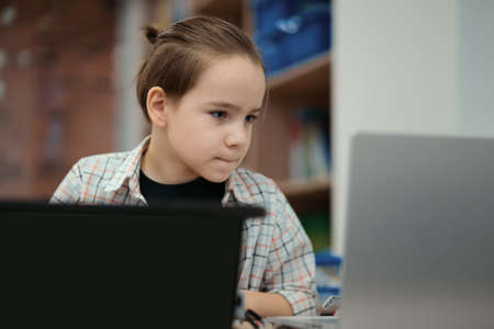 Boy using a laptop to program assembled robot from plastic bricks. STEM Education for kids.の写真素材