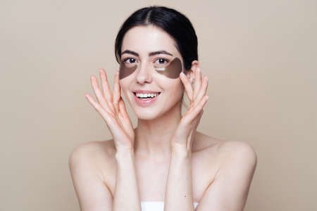 Eye patch, Beautiful Woman With Natural skin And Green Hydro Gel Eye Patches under her eyes. Caucasian woman use patches after shower, skin careの写真素材