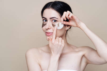 Eye patch, Beautiful Woman With Natural skin And Green Hydro Gel Eye Patches under her eyes. Caucasian woman use patches after shower, skin careの写真素材