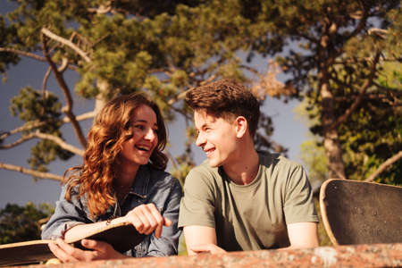 Caucasian skateboarder couple standing together prepare themselves to surf skate in the city Handsome man and beautiful woman enjoy skateboard exercising.の写真素材