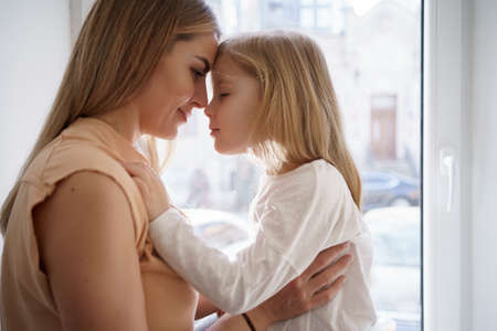 Togetherness Concept. Daughter hugging her mum. Love family, parenthood childhood concept. Mom and her kid playing togetherの写真素材