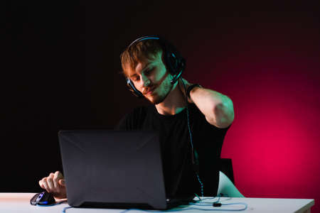 Portrait of Software Developer. Hacker. Gamer Wearing Headset Sitting at His Desk and Working....