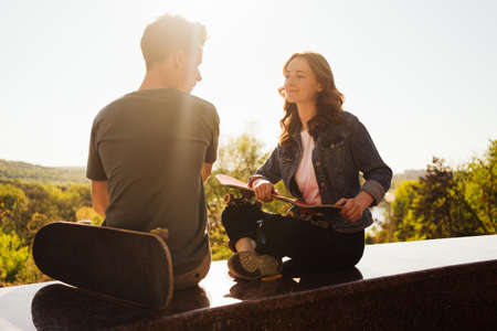 Caucasian skateboarder couple standing together prepare themselves to surf skate in the city...