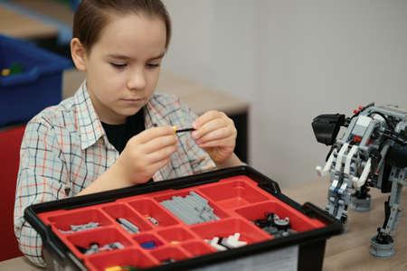 Boy Works on a Fully Functional Programable Robot for His School Robotics Club Project.の写真素材