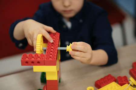 One kid choose parts of robotic electric toys for his age of four to build robots at robotics school lesson.の写真素材