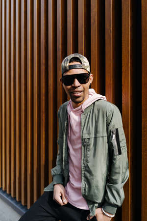 Afro Man in good mood with sunglasses poses over modern urban background.の写真素材