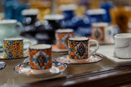 Colorful Turkish cups background. Ornamental cups with plates among different other mugsの写真素材