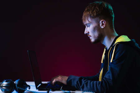 Portrait of Software Developer. Hacker. Gamer Wearing Headset Sitting at His Desk and Working....