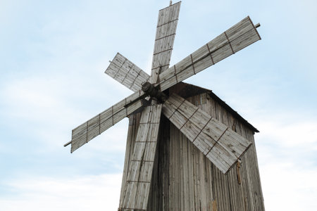 Old wooden windmill for grinding grain into flour, against the background of a clear, blue sky, copy spaceの写真素材