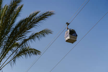 Tourists riding a gondola of the cable car against blue skyの写真素材