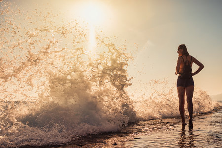 Cheerful young woman enjoying freedom on vacation on the seaside