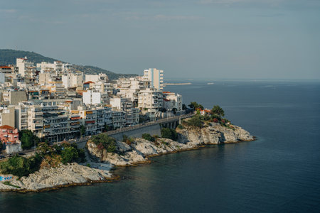 KAVALA, GREECE - July 7, 2022: Beautiful view of the city on the rocks near the seawith sky in...