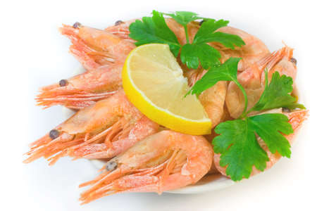 Shrimps on plate with green parsley and lemon segmentの写真素材