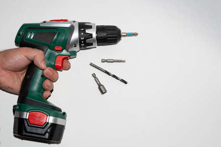 The drill is rechargeable, in the hand before starting work. Working with a screwdriver, with a cross bat.の写真素材