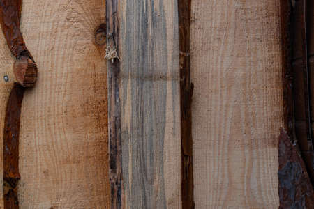 The background is made of textured, untreated wooden boards. The texture of wood fibers, bark and knots. The wall of a warehouse for firewood, in a remote village in Russia.の写真素材