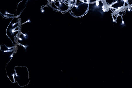 A shining silver garland forms a frame and a copy space. Christmas tree toys create a desire to celebrate Christmas and New Year. A graphic resource for greeting cards.の写真素材