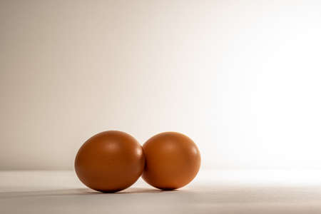 Two chicken, brown eggs, on a light background. Two textured chicken eggs, with a textured surface.の写真素材