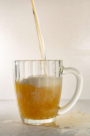 Beer glass, filled with foamy, light beer. Beer mug, beer jet, light beer with foam.の写真素材