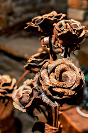 A bouquet of roses, forged by a blacksmith from metal, stands in a blacksmith's workshop. A collection of products made by blacksmiths by hand.の写真素材