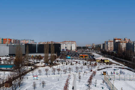 Photo of a parking lot, next to a shopping center. Urban landscape, in a winter setting, sunny...