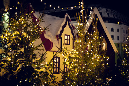Decoration in the form of a fairy-tale house, among Christmas trees and garlands. Christmas trees, garlands and decorations in the form of a fairy-tale house.の写真素材