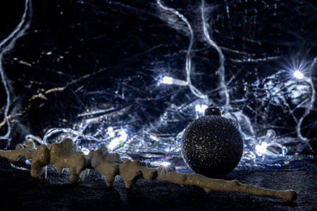 A silver textured ball and a Christmas tree toy in the form of an icicle. Silver and light Christmas toys, on a dark background.の写真素材