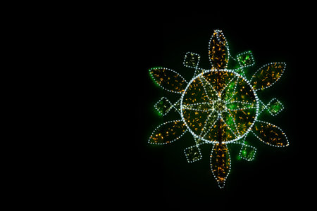 New Year's garlands are stretched in the form of a multifaceted snowflake. A bright bokeh of the lights of New Year's garlands.の写真素材