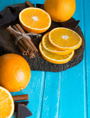 Ingredients for a healthy breakfast - orange, cinnamon, black chocolate on a blue wooden background. Colorful holiday compositionの写真素材