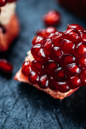 Fresh ripe pomegranate on a slate plate kitchen tableの写真素材